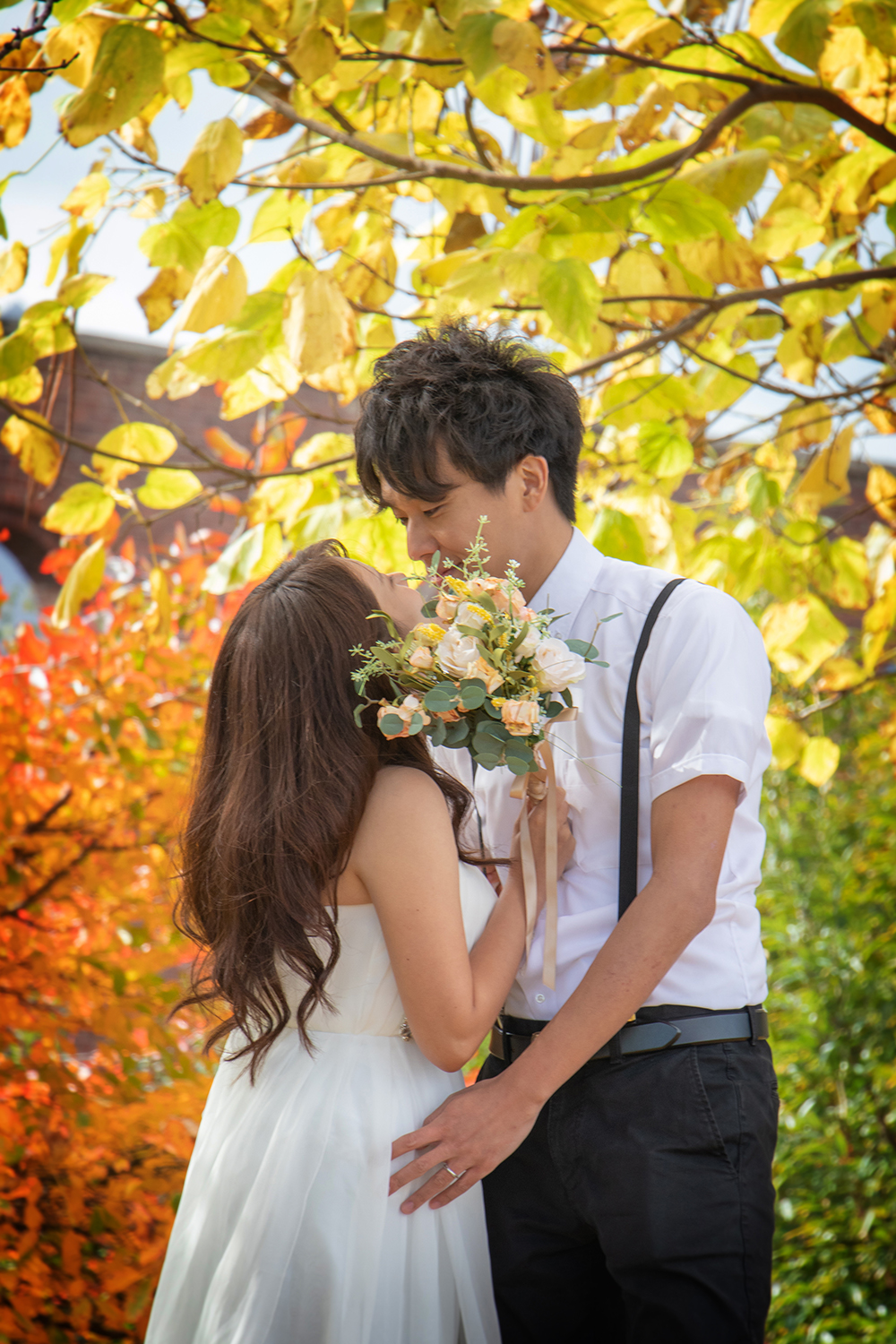 紅葉のダンボエリアでウェディングフォトを撮影する日本人カップル