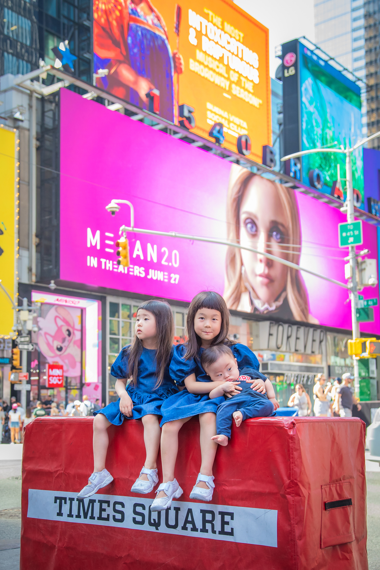 Candid photo of kids enjoying the lively atmosphere of Times Square in Manhattan, NYC.